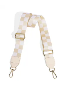 Detail of adjustable beige checkerboard bag strap with premium gold metal swivel hooks