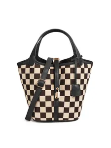 Détail du sac seau à damier avec cadenas doré et bandoulière réglable en cuir