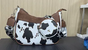 Detail of cow print crescent bag with adjustable jacquard strap and small round pouch