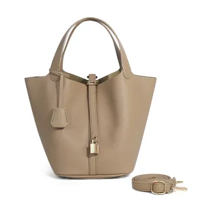 Détail du sac seau en cuir grainé avec cadenas doré et bandoulière réglable pratique
