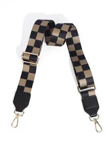 Close-up of checkered wide bag strap with gold metal hooks and adjustable buckle