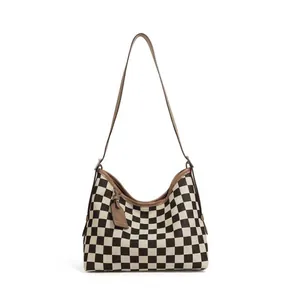 Detail view of checkerboard shoulder bag showing curved silhouette and leather hangtag