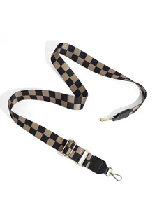 Detail of adjustable checkerboard shoulder strap with gold-tone metal hooks and buckles