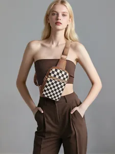Détail du sac bandoulière à damier avec fermetures dorées et sangle marron réglable