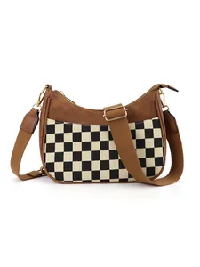 Close-up of checkerboard canvas hobo bag with brown leather and wide textile strap