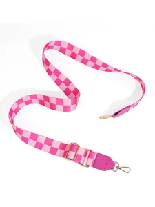 Close-up of pink checkered wide bag strap with gold lobster clasps and metal buckle