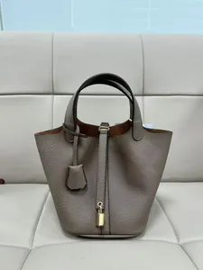Close-up of pebble grain PU leather bucket bag with gold padlock and strap detail
