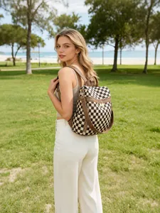 Outdoor shot of checkerboard backpack with premium leather straps and side pockets