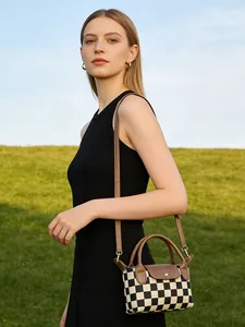 Vue détaillée d'un mini sac en toile à damier avec rabat en cuir marron et bandoulière