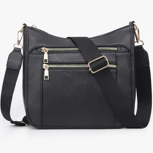 Dettaglio borsa a tracolla in pelle nera con doppie zip dorate e ampia tracolla in nylon