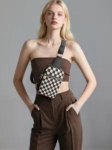 Détail du sac de poitrine à damier avec zip doré et bandoulière en toile réglable