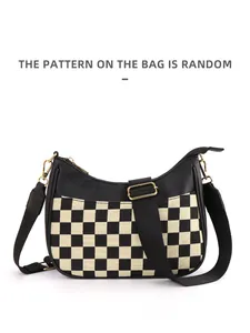 Detail of checkered crescent bag showing the black and white pattern with adjustable strap