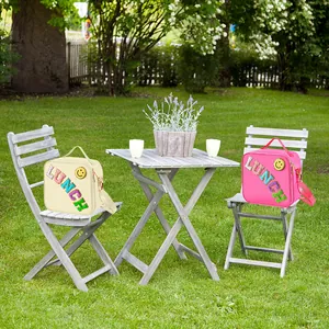 Close-up of beige and pink nylon lunch bags with LUNCH lettering and adjustable shoulder straps