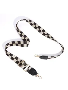 Adjustable black and white checkerboard strap with gold metal swivel clasps and leather ends