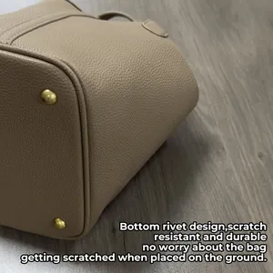Bottom view of beige PU leather bucket bag featuring protective gold-tone metal feet