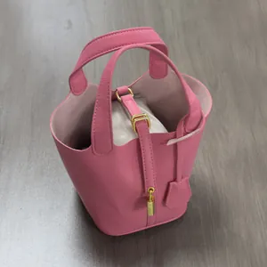 Top view of bright pink textured PU leather bucket bag with inner organizer and gold lock