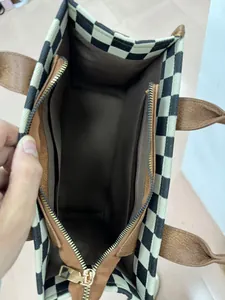 Interior view of checkered straw tote bag showing brown fabric lining and functional pockets