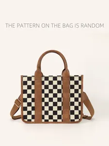 Detail of checkerboard tote bag with brown leather handles and adjustable shoulder strap