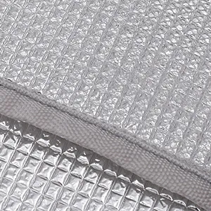 Close-up of waterproof thermal aluminum lining with grid texture and grey fabric edge