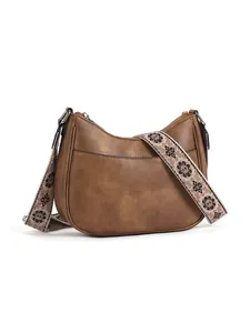 Detail of brown hobo bag featuring floral woven strap and smooth leather texture