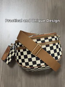 Detail view of denim checkerboard shell bag with gold zippers and adjustable strap