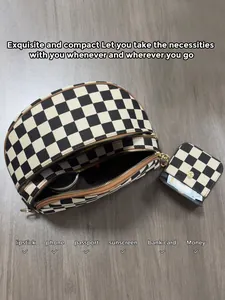 Close-up of checkerboard canvas shell bag with brown leather trim and golden zipper