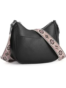 Close-up of black litchi pattern crescent bag with vintage floral woven shoulder strap