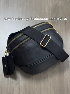 Detail view of black faux leather crossbody bag with dual golden zippers and wide strap