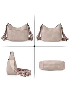 Detailed views of beige crescent crossbody bag with ethnic floral patterned woven strap
