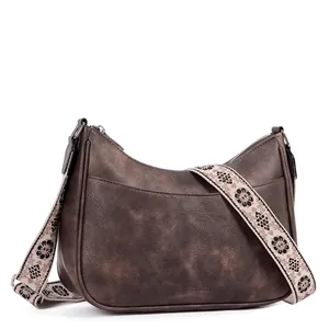 Detail of vintage brown crescent bag with floral embroidered wide strap and metal zipper