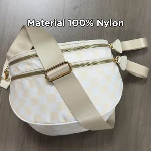 Detailed view of checkered nylon crossbody bag with gold double zippers and 100% nylon material