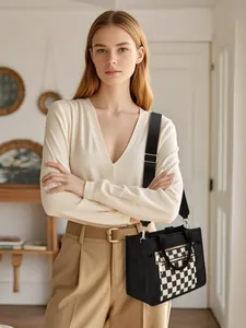 Detail of black PU crossbody bag featuring a checkered front pocket and dual zippers