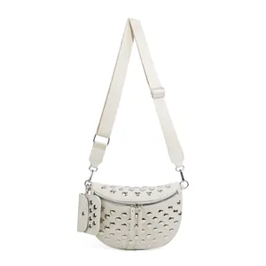 Détail du sac banane en paille blanc cassé avec clous argentés et large bandoulière