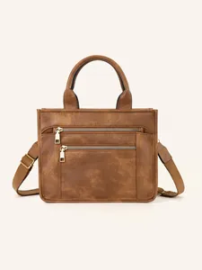 Detail of brown PU leather tote bag with dual gold zippers and adjustable shoulder strap