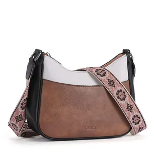 Close-up of tricolor leather crossbody bag with floral strap and embossed CLUCI logo