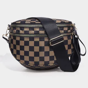 Detail of checkered shell bag showing dual gold zippers and durable fabric texture