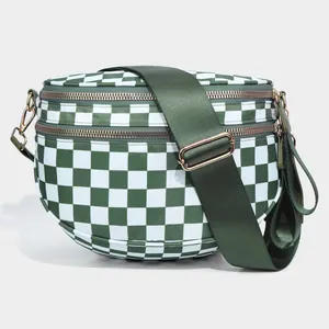 Detail view of checkerboard crossbody bag with dual metal zippers and wide nylon strap