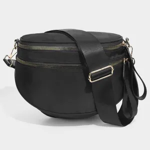 Detail of black nylon crossbody shell bag with double zippers and gold-tone hardware