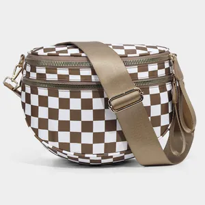 Close-up of checkered nylon shell bag featuring dual gold zippers and adjustable strap