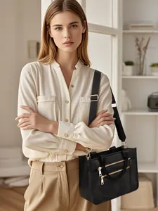 Detail of black pebbled PU tote with gold zippers, dual handles and wide nylon strap