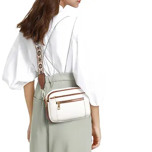 Women's chic white PU leather crossbody bag with brown trim and ethnic patterned strap