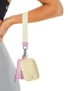 Nahaufnahme der Handgelenktasche mit rosa und beigen Mini-Geldbörsen am Schlüsselband
