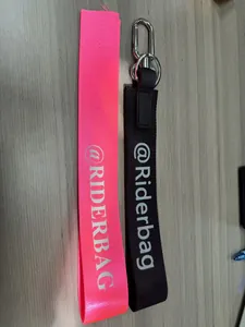 Dettaglio di portachiavi in tessuto intrecciato rosa e nero con moschettoni in metallo