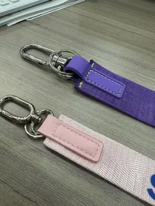 Dettaglio di cinturini da polso in nylon intrecciato viola e rosa con fibbie in metallo lucido