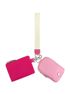Detail der Doppelbeutel-Handgelenktasche mit rosa Reißverschlusstaschen am Trageriemen