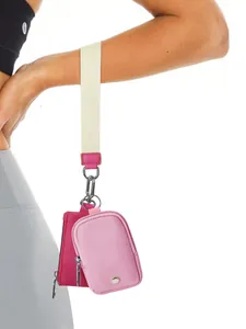 Details von zwei rosa Mini-Handgelenktaschen mit Metallclips an einem Armband