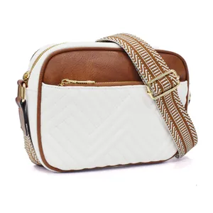 Close-up of bicolor camera bag with V-quilt pattern and geometric wide strap