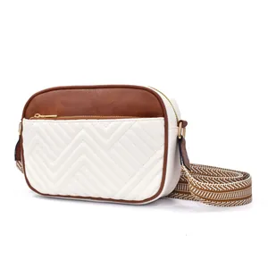 Detail of white and brown checkered camera bag with V-quilting and patterned strap