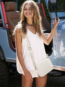 White quilted crossbody bag with wide patterned strap and gold bead detail