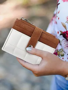 Detailed shot of two-tone quilted leather wallet with zipper pocket and card slots